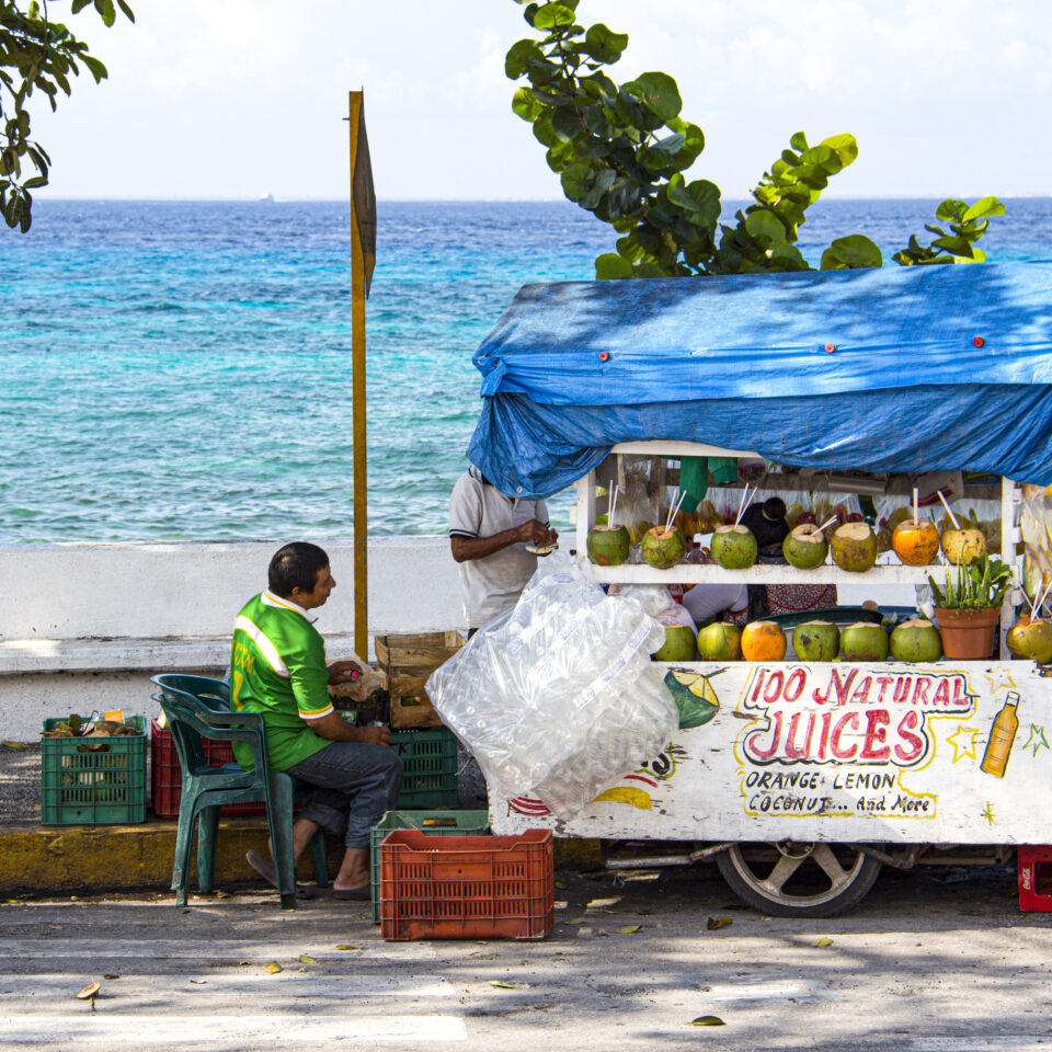 Imagen comercio cozumel, vendedor ambulante, mar caribe de fondo, mar azul cozumel